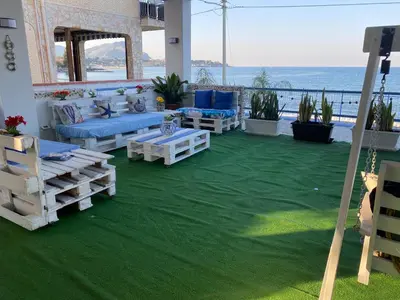 a patio with couches and a view of the ocean at Villa GLORIA intero alloggio sulla spiaggia 8 posti letto 15 minuti da Palermo e 35 da Cefalu in Casteldaccia