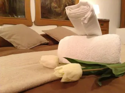 a pile of towels on a bed with flowers at Verdi Apartment in Castellammare del Golfo