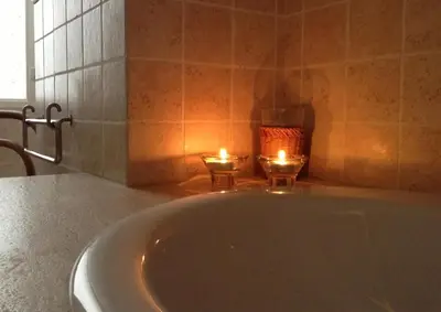 a bath tub with two candles in a bathroom at Verdi Apartment in Castellammare del Golfo