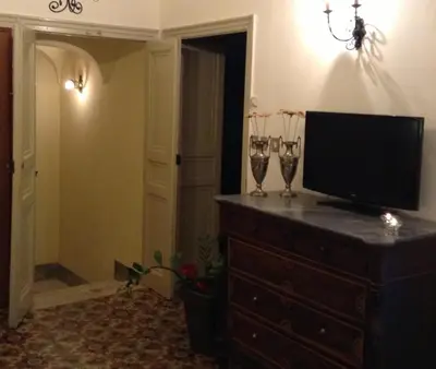a television on a dresser with two wine glasses on it at Verdi Apartment in Castellammare del Golfo