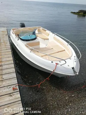 a white boat is tied to a dock at CASE VANELLA GRANDE aspra Bagheria in Bagheria