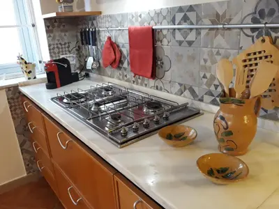 a kitchen counter with a stove and some utensils at Olivuzza Apartment in Palermo