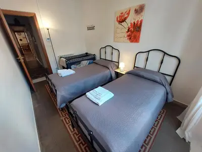 two twin beds in a room with a mirror at Olivuzza Apartment in Palermo