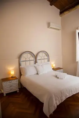 a bedroom with a large white bed with two lamps at Dimora Sinibaldi in Palermo