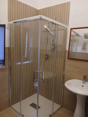 a shower with a glass door next to a sink at Casa da Michelino in Palermo