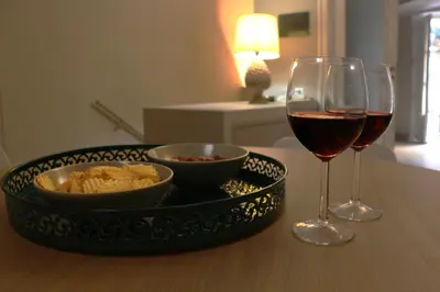 a table with a glass of wine and a bowl of food and a bowl at Palazzo Cutò suite & charme in Palermo