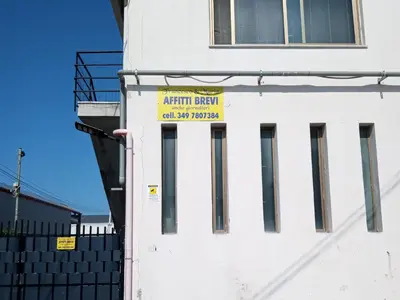 a white building with a yellow sign on it at Francesco&Maria in Villaggio Tedeschi