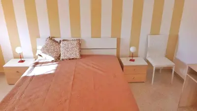 a bedroom with a large bed and a chair at Francesco&Maria in Villaggio Tedeschi