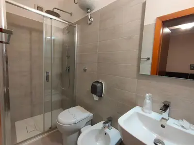 a bathroom with a shower and a toilet and a sink at Hotel La Rocca in Roccapalumba