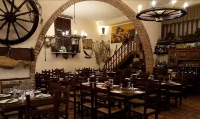 a dining room with tables and chairs and a staircase at Hotel La Rocca in Roccapalumba