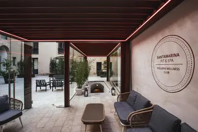 a gray chair and a white table and a table with a lamp at PALAZZO SANTAMARINA Luxury Suite & Spa in Palermo