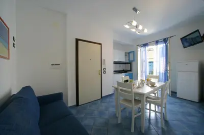 a living room with a couch and a table with chairs at Venere ed Enea - Appartamenti Vista Mare in San Vito lo Capo