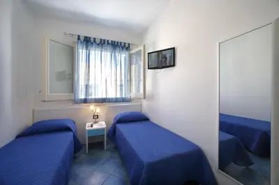 a small room with two beds and a mirror at Venere ed Enea - Appartamenti Vista Mare in San Vito lo Capo