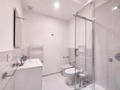 a bathroom with a toilet and a glass shower at Cubacalatafimi Rooms in Palermo