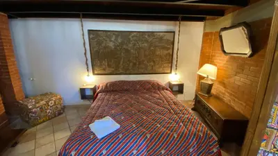 a bedroom with a bed with two lamps and a mirror at Casa Zagato Le Fuoriserie in Palermo