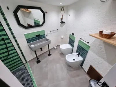 a bathroom with a sink and a toilet and a mirror at Casa Monviso Le fuoriserie in Palermo