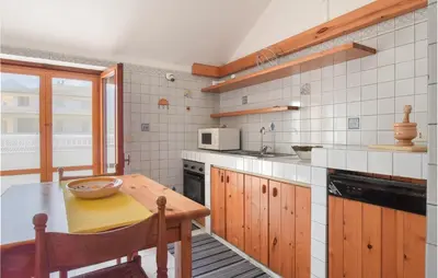 a kitchen with a wooden table and a counter top at Mansarda Belvedere in Alcamo Marina