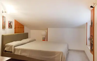 a bedroom with a bed in a white room at Mansarda Belvedere in Alcamo Marina