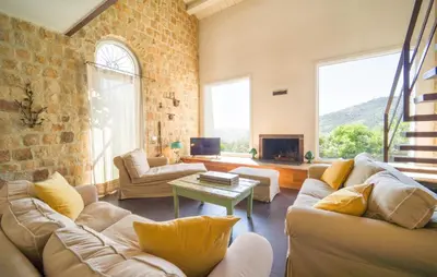 a living room with white furniture and a brick wall at Cerasuola in Alia