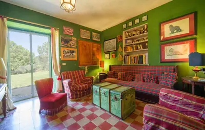 a living room with green walls and a couch and chairs at Biancolilla in Alia