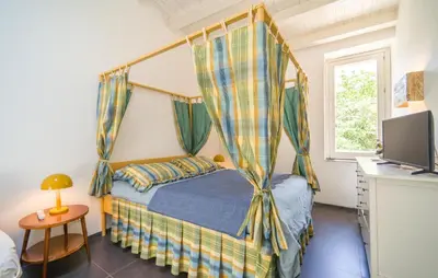 a bedroom with a canopy bed with a desk at Biancolilla in Alia