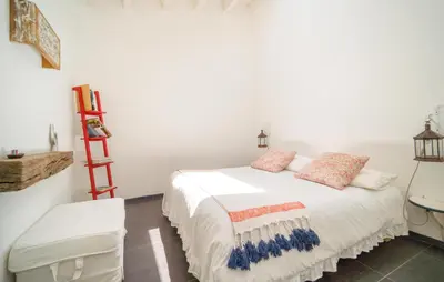 a bedroom with a white bed and a red ladder at Biancolilla in Alia