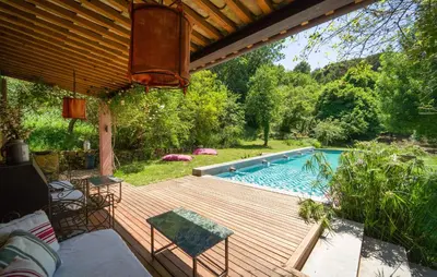 a wooden deck with a swimming pool in a yard at Biancolilla in Alia