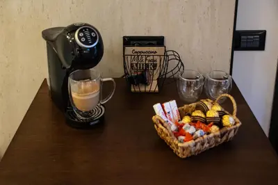 a table with a coffee maker and a basket of food at Real suite spa in Palermo