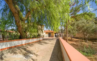 a walkway in a park with a large tree at Villa Spera in Mandra Capreria