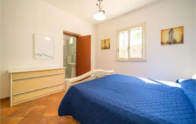a bedroom with a blue bed and a window at Villa Spera in Mandra Capreria