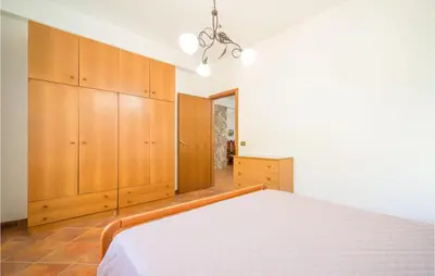 a bedroom with a bed and wooden cabinets at Villa Spera in Mandra Capreria