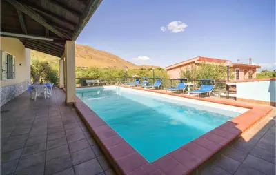 a swimming pool with blue chairs on a patio at Villa Spera in Mandra Capreria