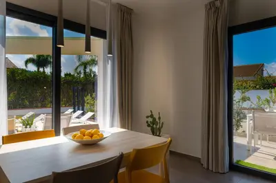 a dining room with a table with a bowl of oranges at Gelso Bianco Boutique Apartments in Campofelice di Roccella