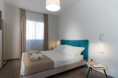 a bedroom with a large bed and a table at Gelso Bianco Boutique Apartments in Campofelice di Roccella