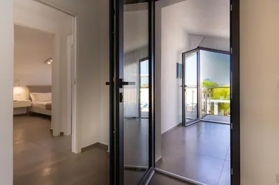 a glass door leading to a room with a bedroom at Gelso Bianco Boutique Apartments in Campofelice di Roccella