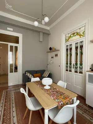 a living room with a wooden table and chairs at Arricría Room Suite in Palermo
