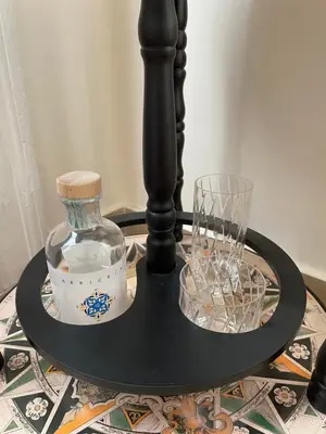 a black table with a bottle and glasses on it at Arricría Room Suite in Palermo