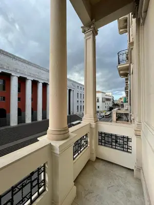a balcony with columns and a view of a city at Arricría Room Suite in Palermo