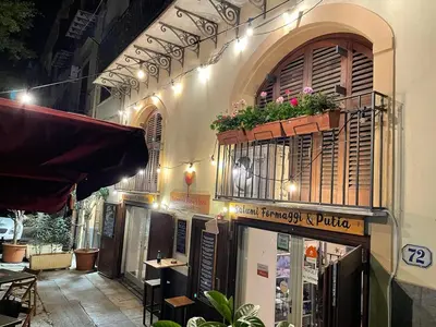 a building with a balcony with flowers on it at Posto al Capo in Palermo