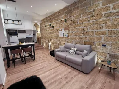 a living room with a couch and a brick wall at Bea Home in Palermo