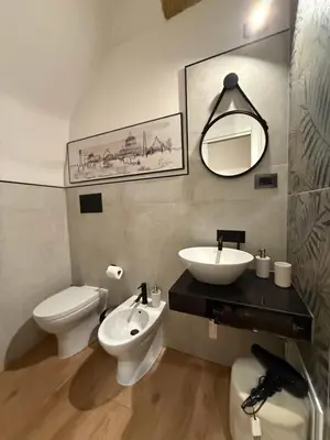 a bathroom with a sink and a toilet and a mirror at Bea Home in Palermo