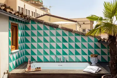 a bathroom with a green and white tiled wall at Sui Tetti di Balarm Boutique Rooms in Palermo