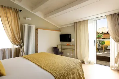 a bedroom with a bed and a balcony with a television at Sui Tetti di Balarm Boutique Rooms in Palermo