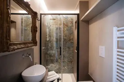 a bathroom with a shower with a toilet and a sink at Sui Tetti di Balarm Boutique Rooms in Palermo
