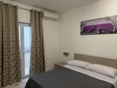 a bedroom with a bed and a large window at Oreto Apartment in Palermo