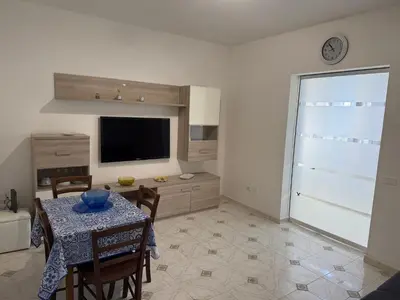 a living room with a table and a television at Oreto Apartment in Palermo