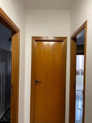 a wooden door in a room with a hallway at Oreto Apartment in Palermo