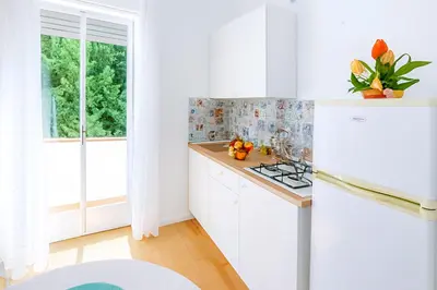 a white kitchen with white cabinets and a window at Perla Home Speciale Vacanze 2026, Casa perfetta per gruppi coppie e famiglie vivi la Sicilia a modo tuo in Alcamo