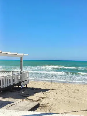 a bench on the beach with a fishing pole at Perla Home Speciale Vacanze 2026, Casa perfetta per gruppi coppie e famiglie vivi la Sicilia a modo tuo in Alcamo