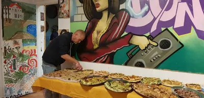 a man standing next to a table with plates of food at A Casa di Amici in Palermo